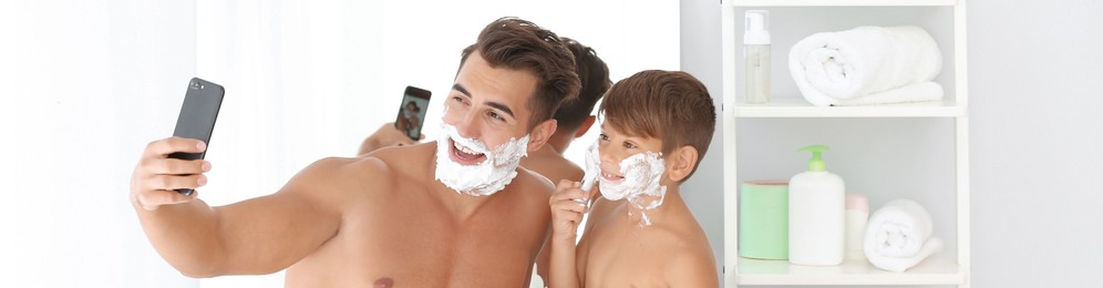 Image of Father and son taking selfie while shaving in bathroom. Banner design