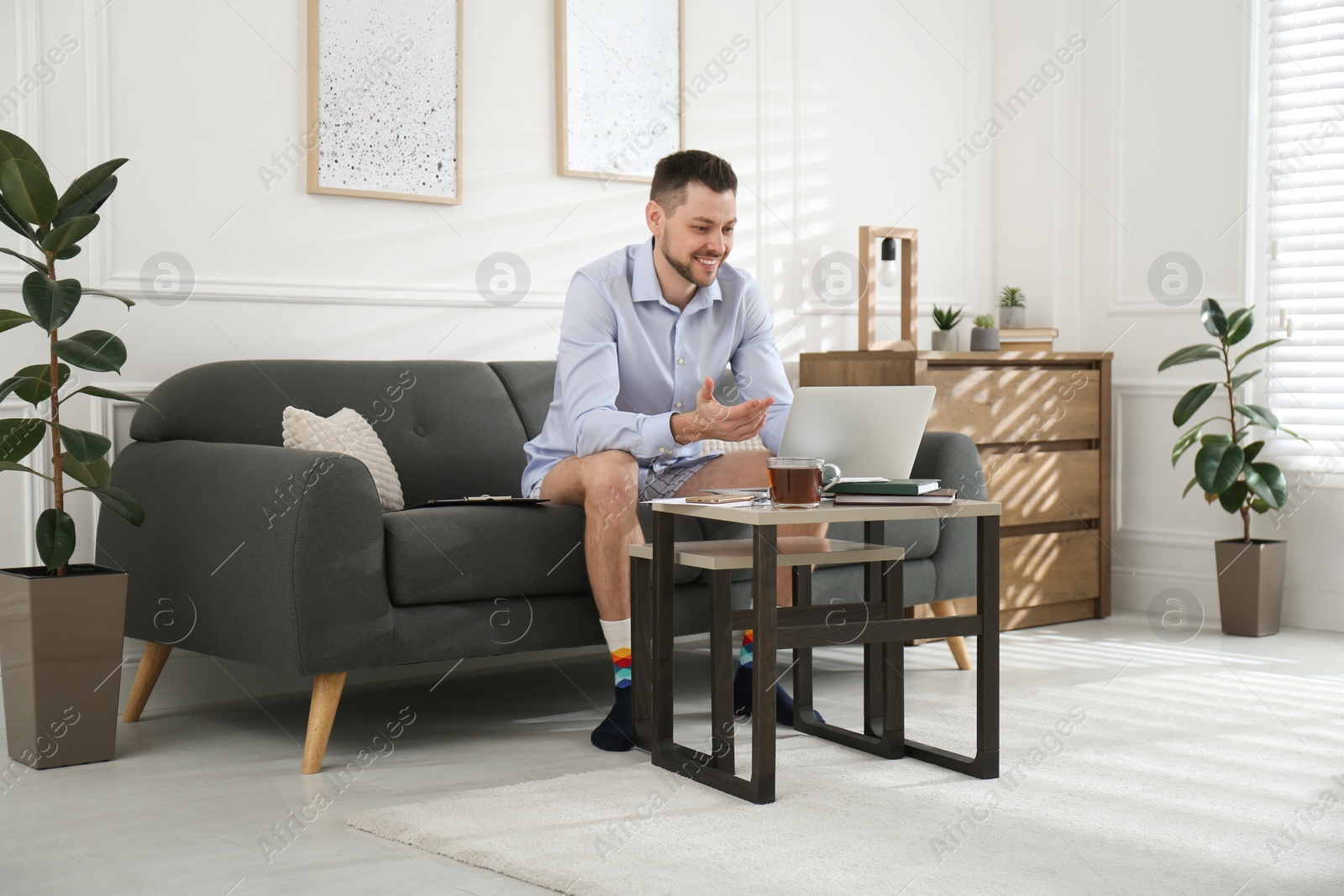 Photo of Businessman in underwear pretending to wear formal clothes during video call at home