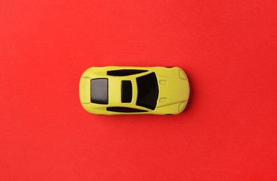 Photo of One yellow car on red background, top view