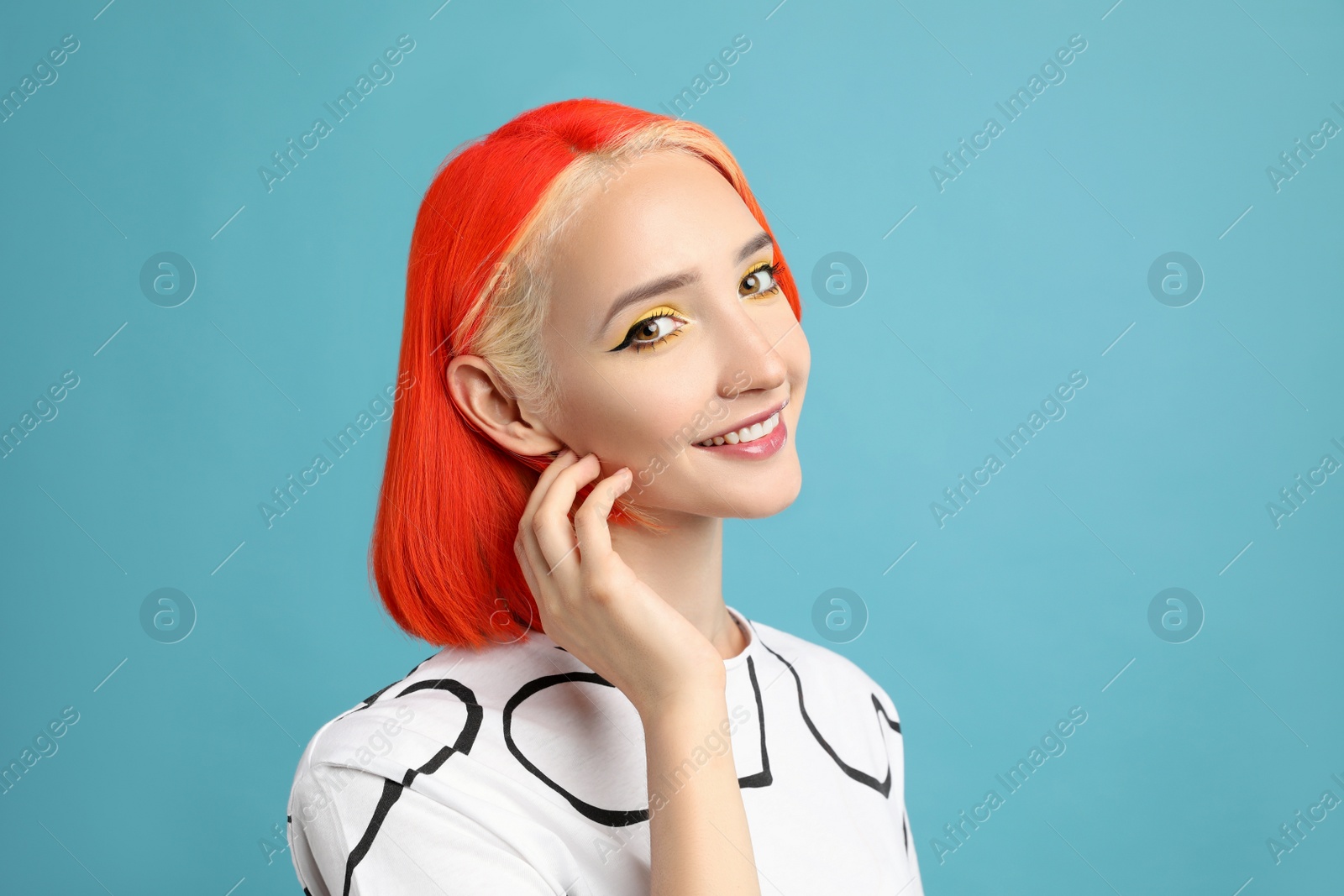 Photo of Beautiful young woman with bright dyed hair on turquoise background