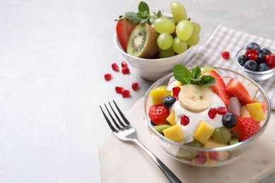 Photo of Delicious fruit salad on light table. Space for text