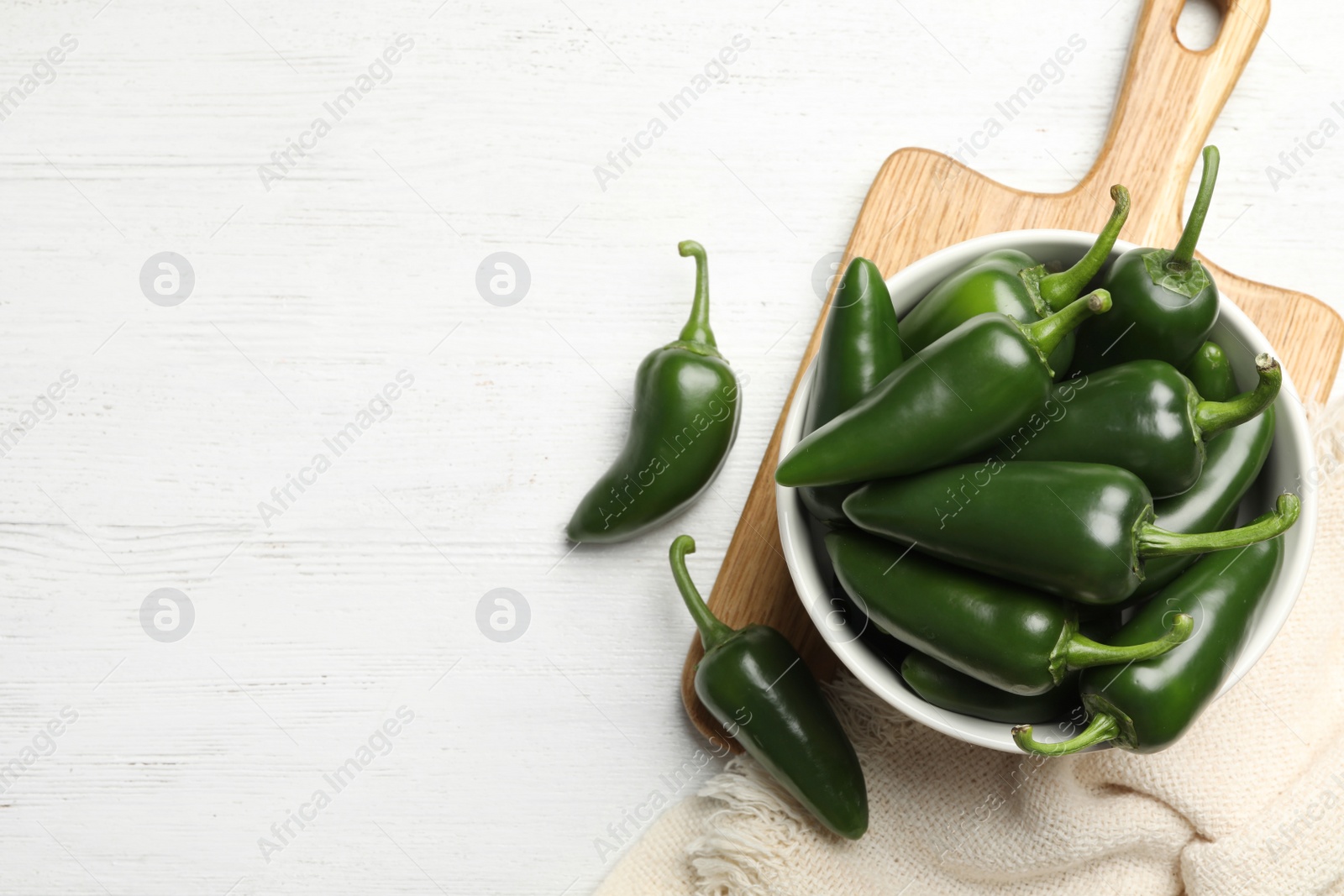 Photo of Green chili peppers on white wooden table, flat lay. Space for text