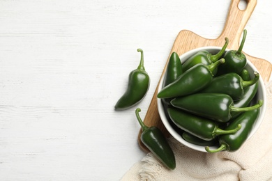 Photo of Green chili peppers on white wooden table, flat lay. Space for text