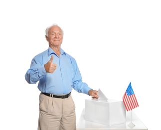 Elderly man putting ballot paper into box against white background