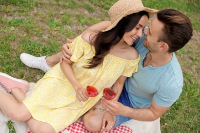 Happy young couple having picnic in park on summer day