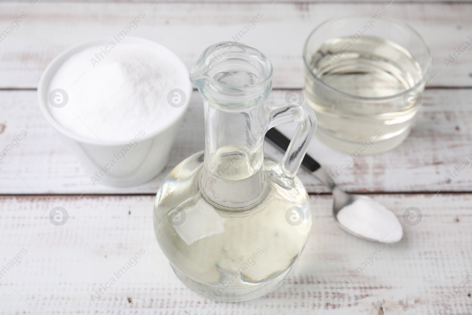 Photo of Vinegar and baking soda on white wooden table