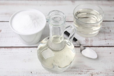 Vinegar and baking soda on white wooden table