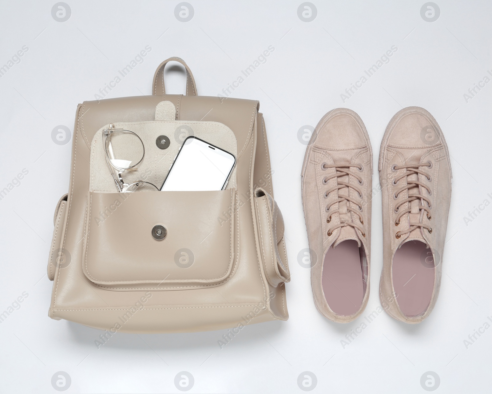 Photo of Stylish casual backpack and sneakers on white background, top view