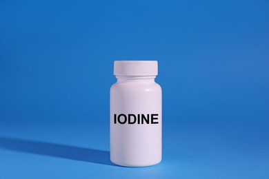 Plastic container of medical iodine on light blue background