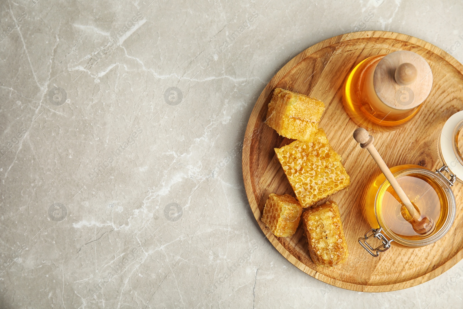 Photo of Delicious honey served on marble table, top view. Space for text