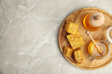 Photo of Delicious honey served on marble table, top view. Space for text