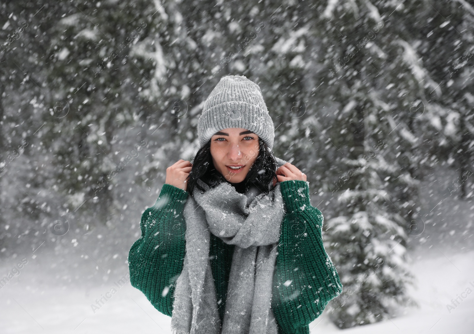 Photo of Young woman wearing warm clothes outdoors on snowy day. Winter vacation