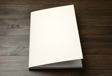 Photo of Blank paper brochure on wooden table. Mockup for design