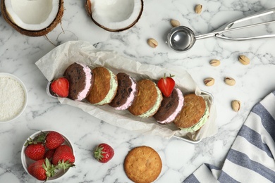 Photo of Different sweet delicious ice cream cookie sandwiches served on table, flat lay