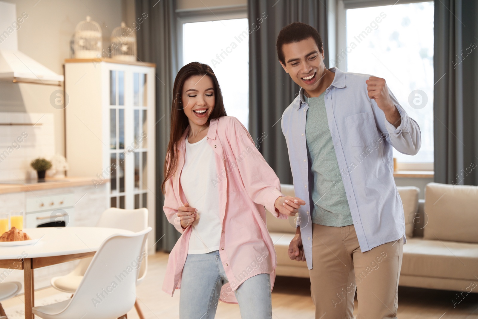 Photo of Lovely young interracial couple dancing at home