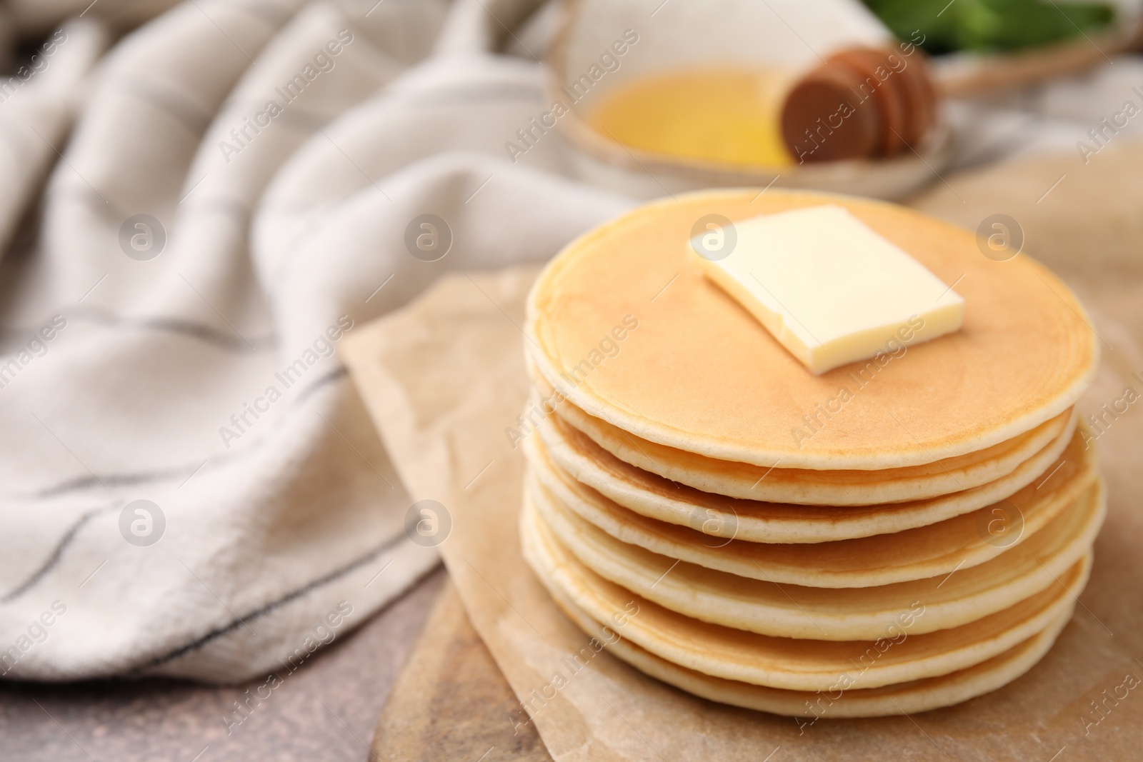 Photo of Delicious pancakes with butter on table, closeup. Space for text