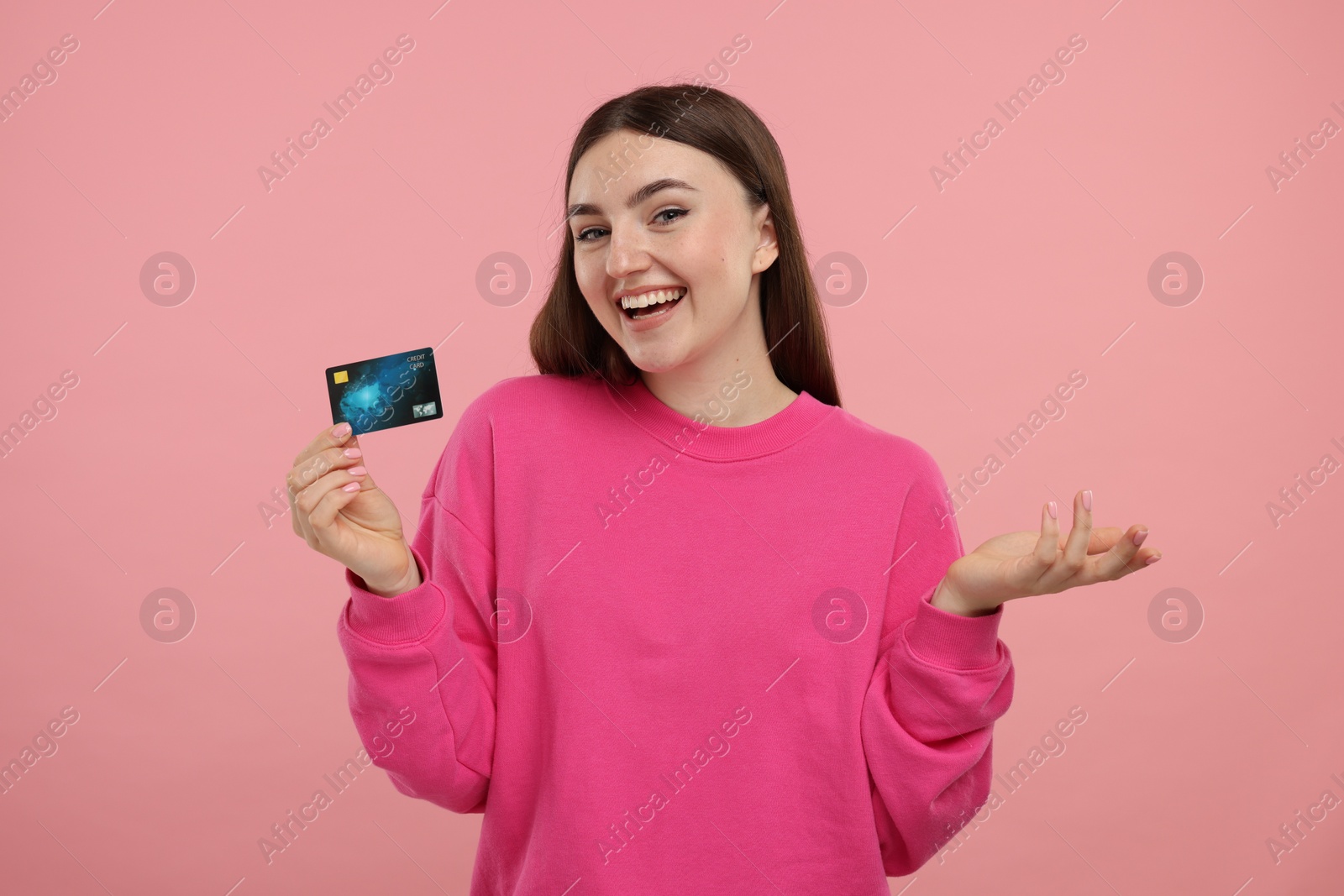 Photo of Happy woman with credit card on pink background