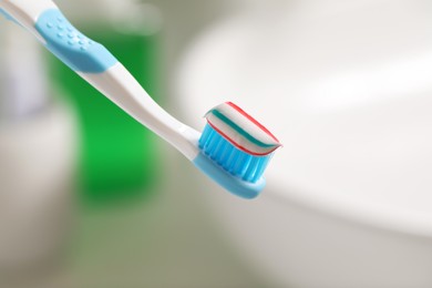 Photo of Toothbrush with paste against blurred background, closeup
