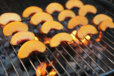 Photo of Modern grill with tasty peach slices, closeup