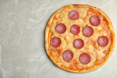 Tasty pepperoni pizza on light grey marble table, top view. Space for text