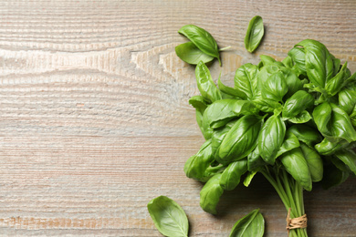Photo of Fresh basil on wooden table, flat lay. Space for text