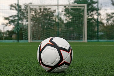 Photo of New soccer ball on green football field
