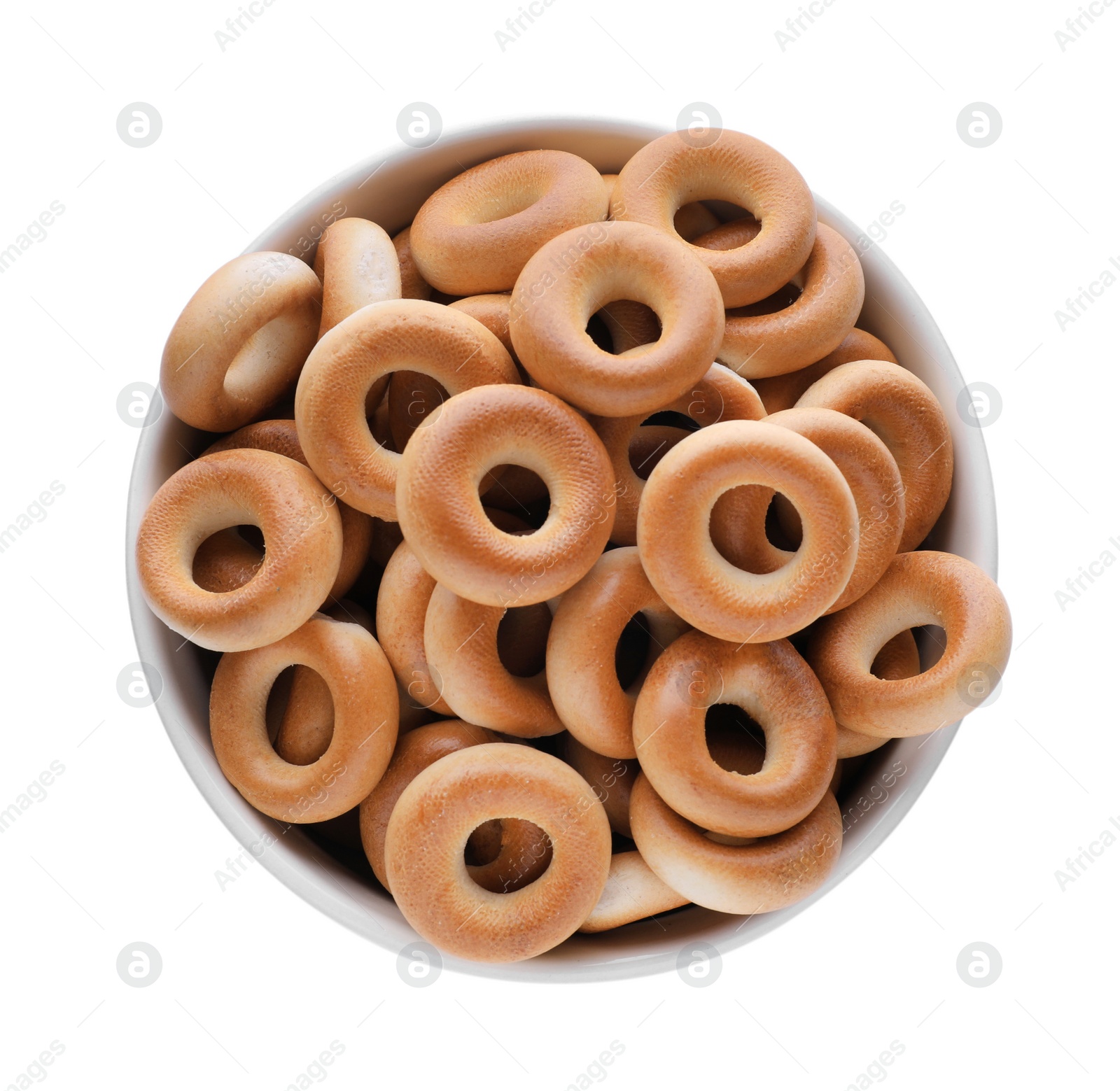 Photo of Bowl with tasty dry bagels (sushki) isolated on white, top view