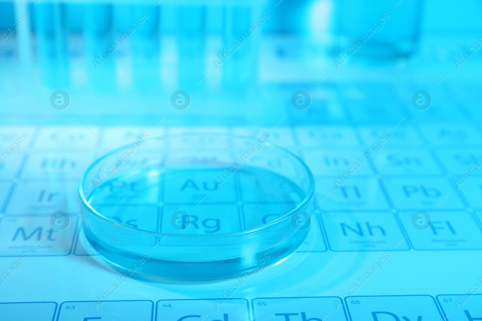 Photo of Petri dish on periodic table of elements, closeup. Color tone effect