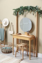 Photo of Stylish room decorated with beautiful eucalyptus garland on dressing table