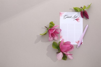 Photo of Guest list, pen and beautiful flowers on grey background, flat lay. Space for text