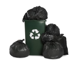 Photo of Dark green recycling bin overfilled with garbage bags on white background