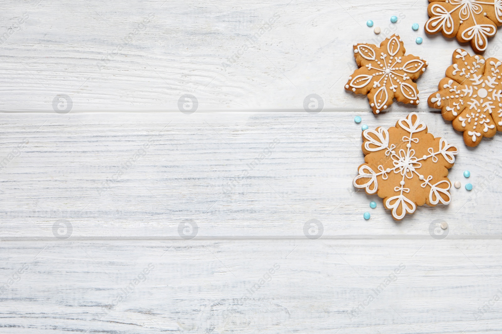 Photo of Tasty Christmas cookies on white wooden table, flat lay. Space for text