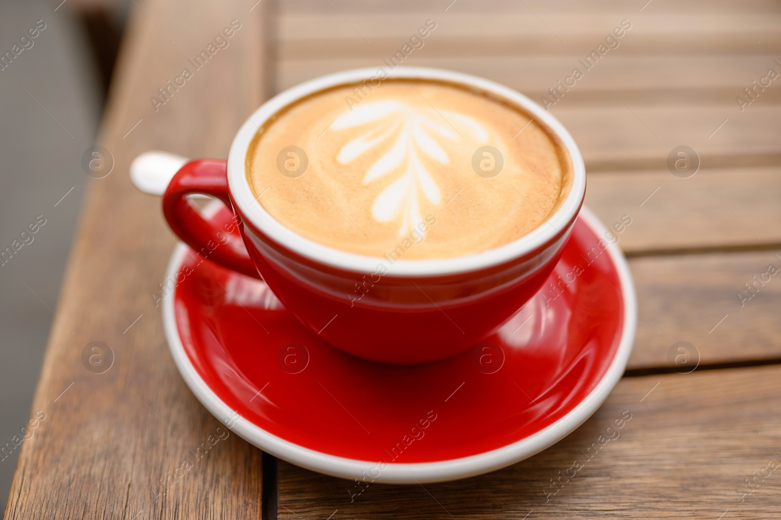 Photo of Cup of aromatic coffee on wooden table, closeup