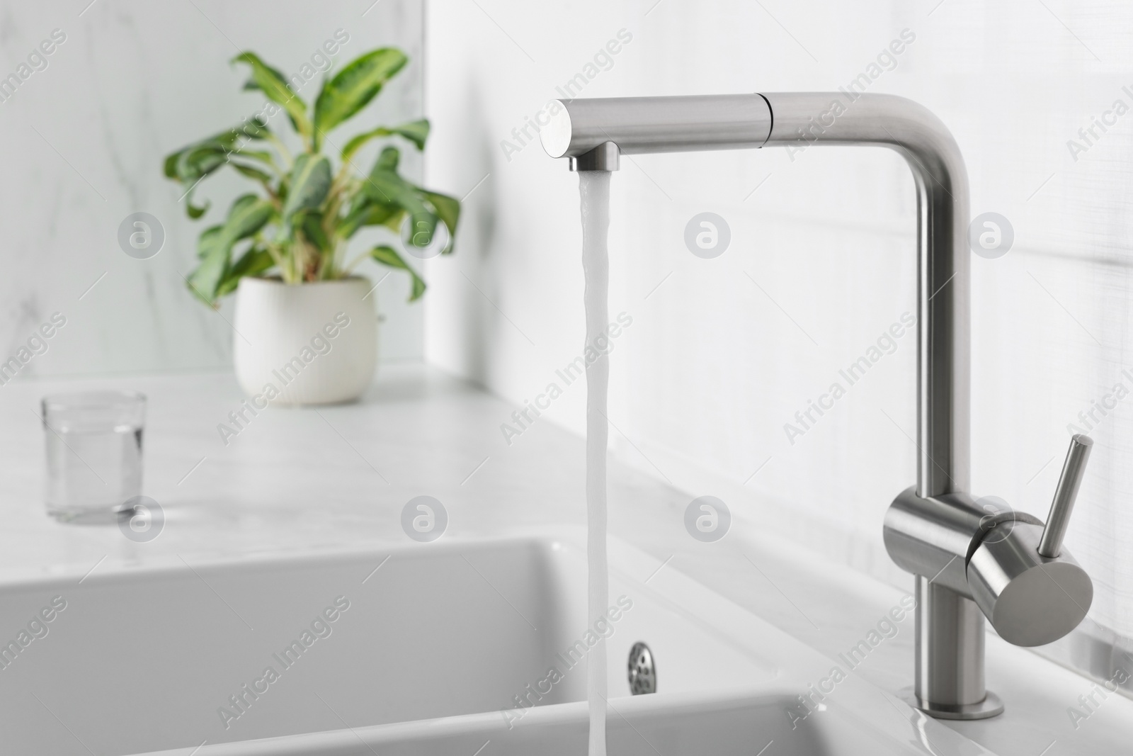 Photo of Stream of water flowing from tap in kitchen