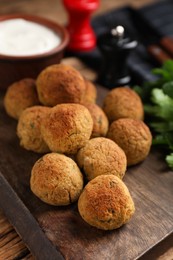 Photo of Delicious falafel balls on wooden table, closeup