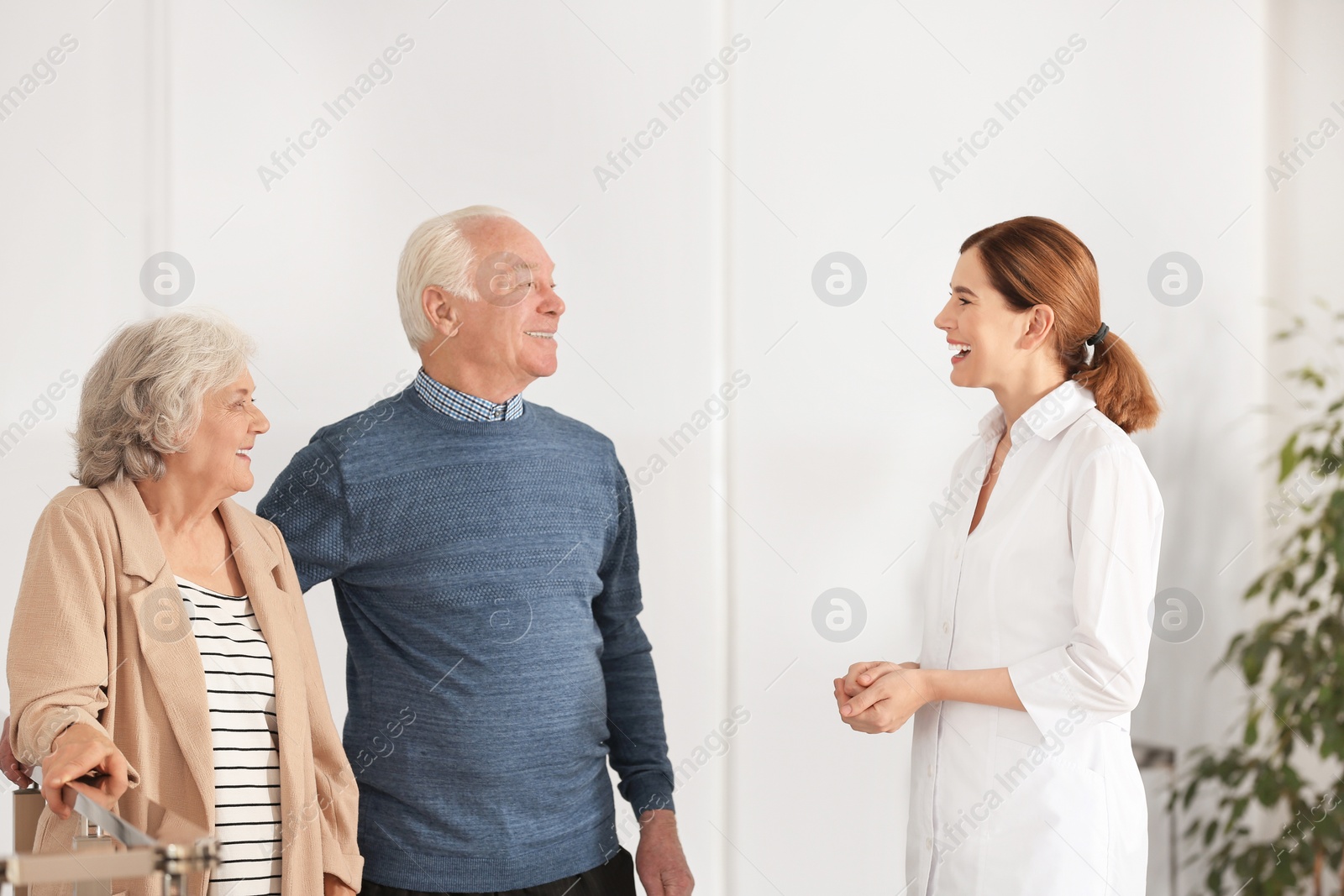Photo of Elderly spouses with female caregiver in room