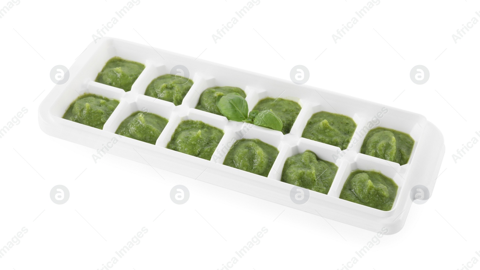 Photo of Puree in ice cube tray on white background. Ready for freezing