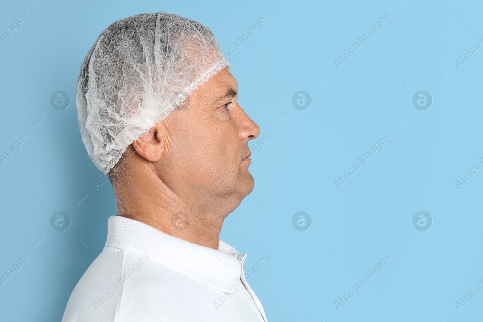 Photo of Mature man with double chin on blue background. Space for text