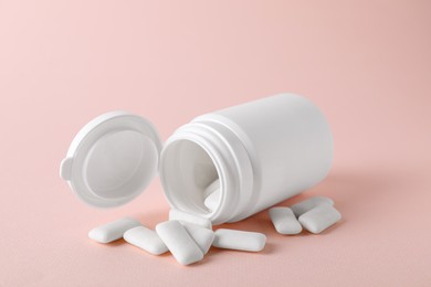 Jar with chewing gums on light pink background