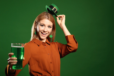 Photo of Young woman with green beer on color background, space for text. St. Patrick's Day celebration