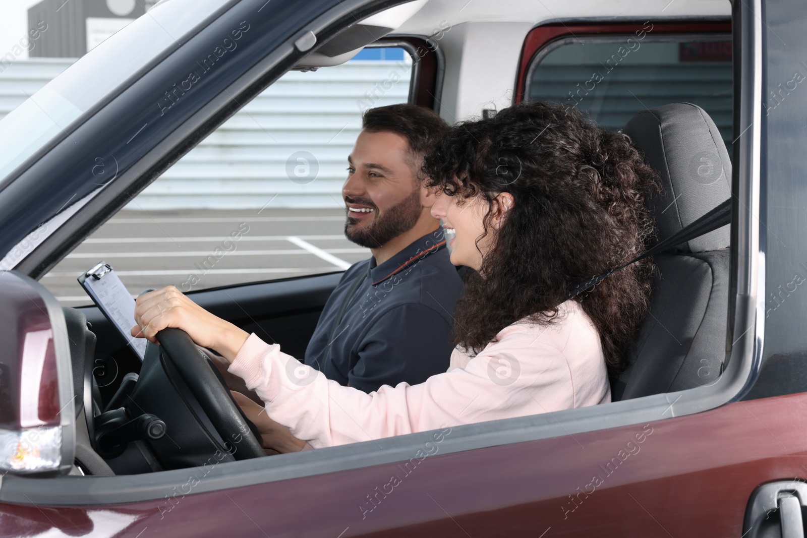 Photo of Driving school. Happy student passing driving test with examiner in car