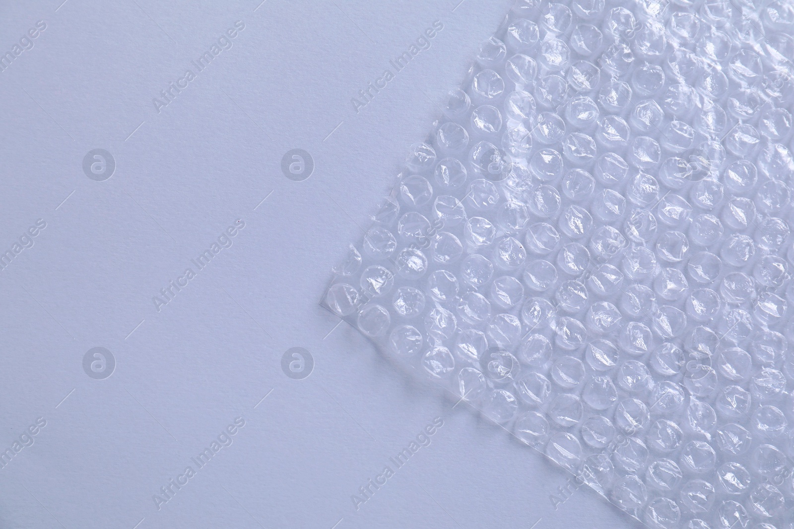 Photo of Transparent bubble wrap on gray background, top view. Space for text