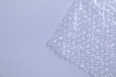 Photo of Transparent bubble wrap on gray background, top view. Space for text