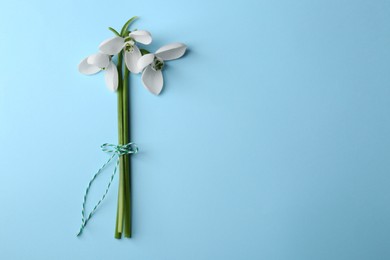 Photo of Beautiful snowdrops on light blue background, flat lay. Space for text