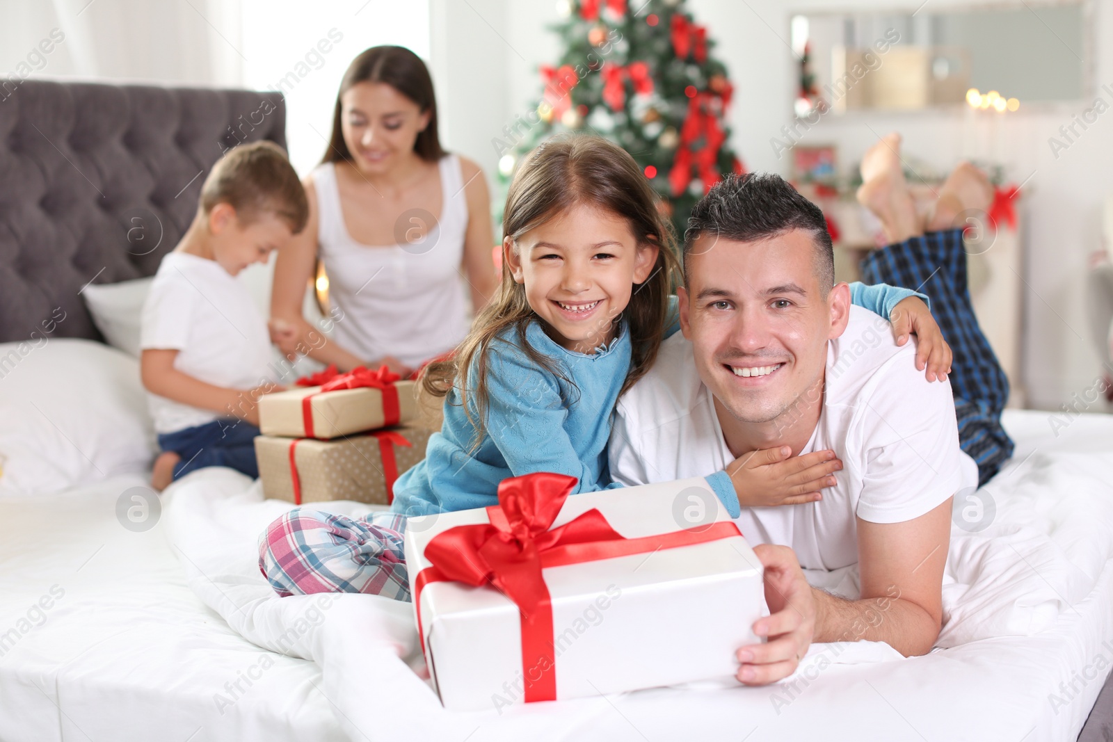 Photo of Happy parents and children exchanging gifts on Christmas morning at home