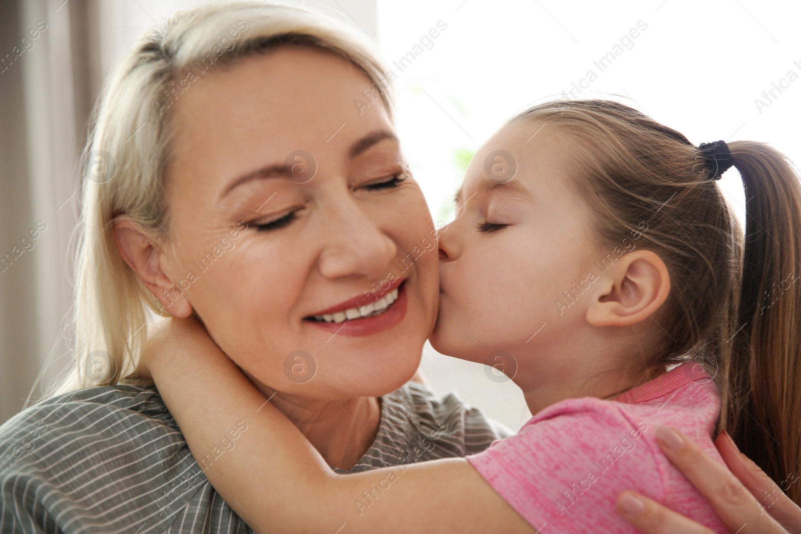 Photo of Mature woman with her little granddaughter at home