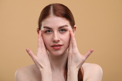 Portrait of beautiful woman with freckles on beige background