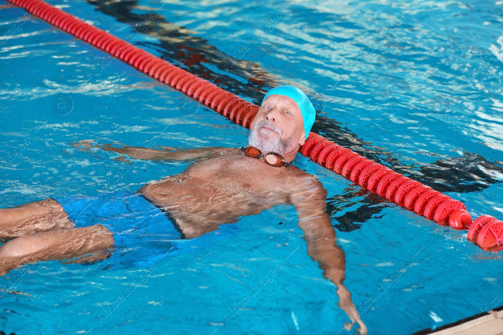 Photo of Sportive senior man in indoor swimming pool