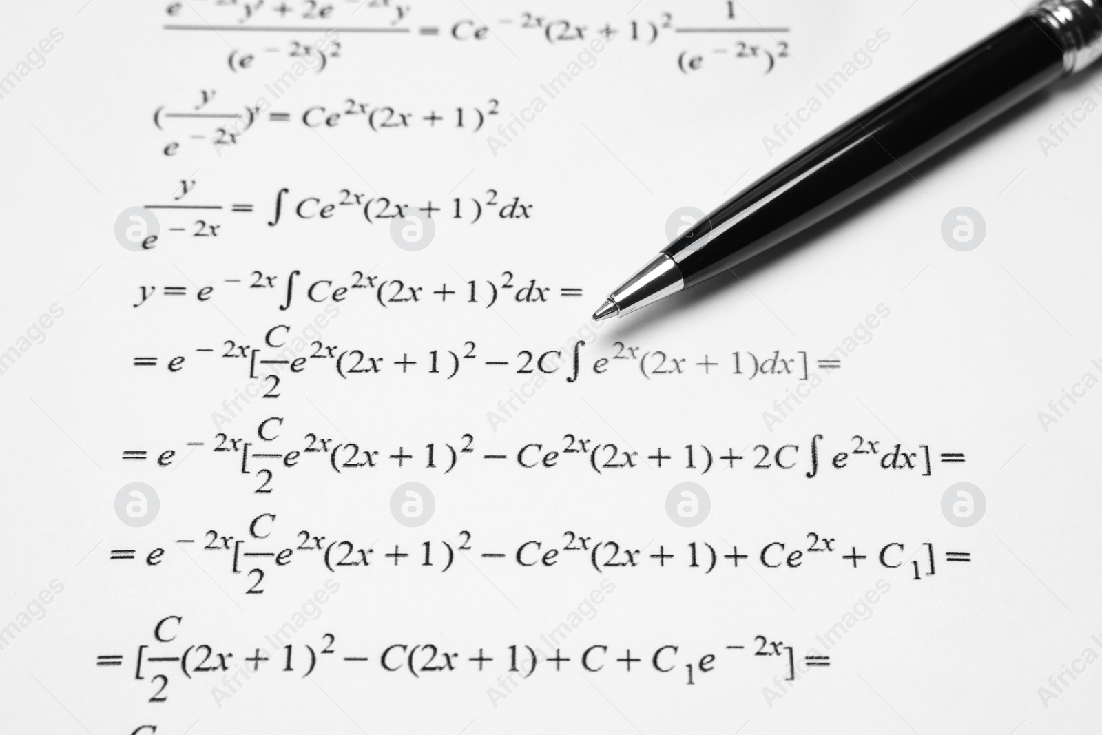 Photo of Sheet of paper with mathematical formulas and pen, closeup