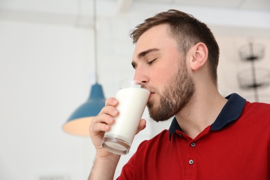 Photo of Young man drinking tasty milk at home
